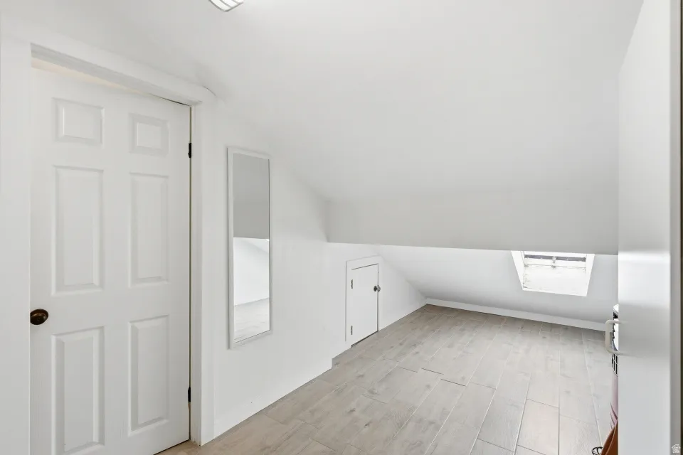 Bonus room featuring vaulted ceiling and light wood-type flooring