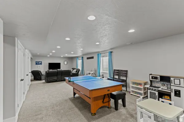 Playroom featuring light colored carpet, recessed lighting, and a textured ceiling