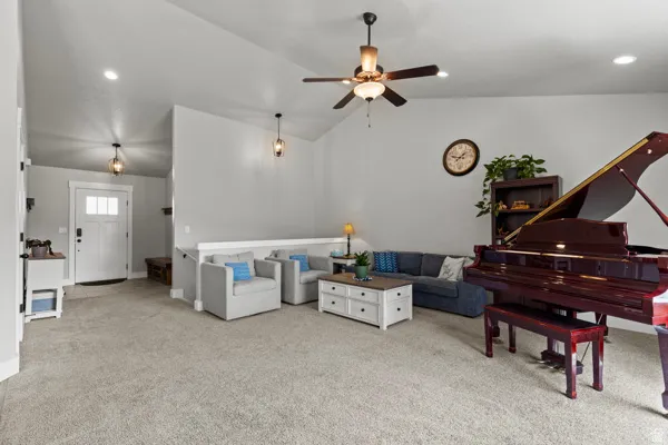 Living room featuring light colored carpet, ceiling fan, lofted ceiling, and recessed lighting