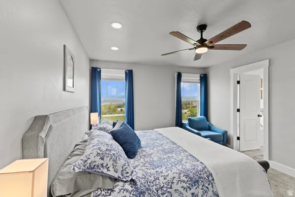 Carpeted bedroom featuring a ceiling fan and baseboards