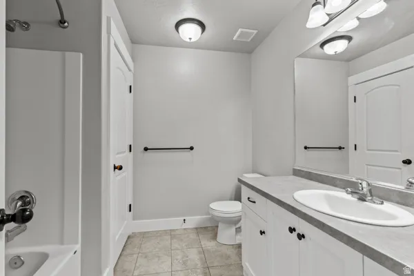 Full bathroom with vanity, light tile patterned floors, and bathtub / shower combination