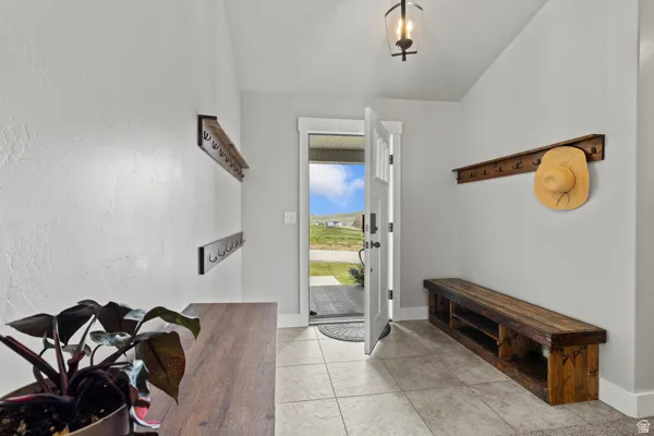 Foyer with light tile patterned flooring and baseboards