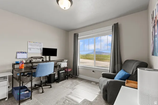 Office space featuring light colored carpet and baseboards