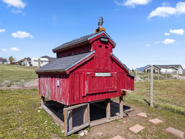 View of chicken coop featuring a lawn