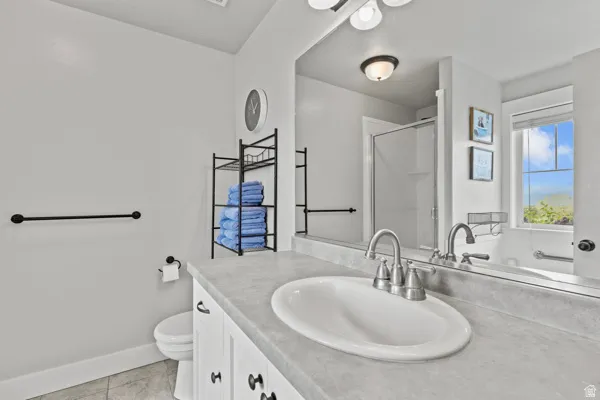 Bathroom with a shower stall, vanity, and light tile patterned flooring