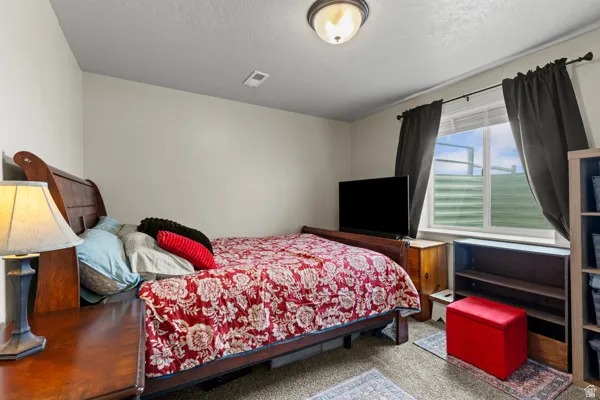 Bedroom featuring carpet and a textured ceiling