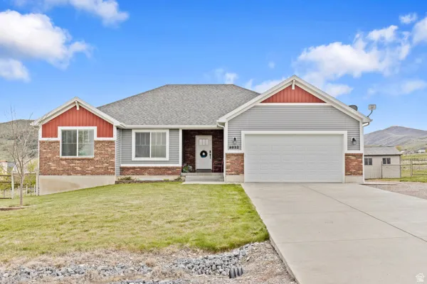 View of front of house featuring a mountain view, an attached garage, concrete driveway, and brick siding
