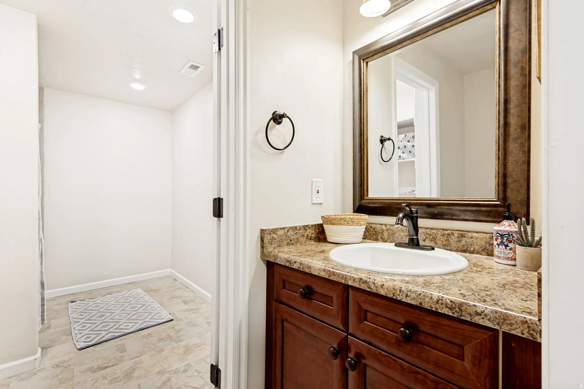 Bathroom with vanity and recessed lighting