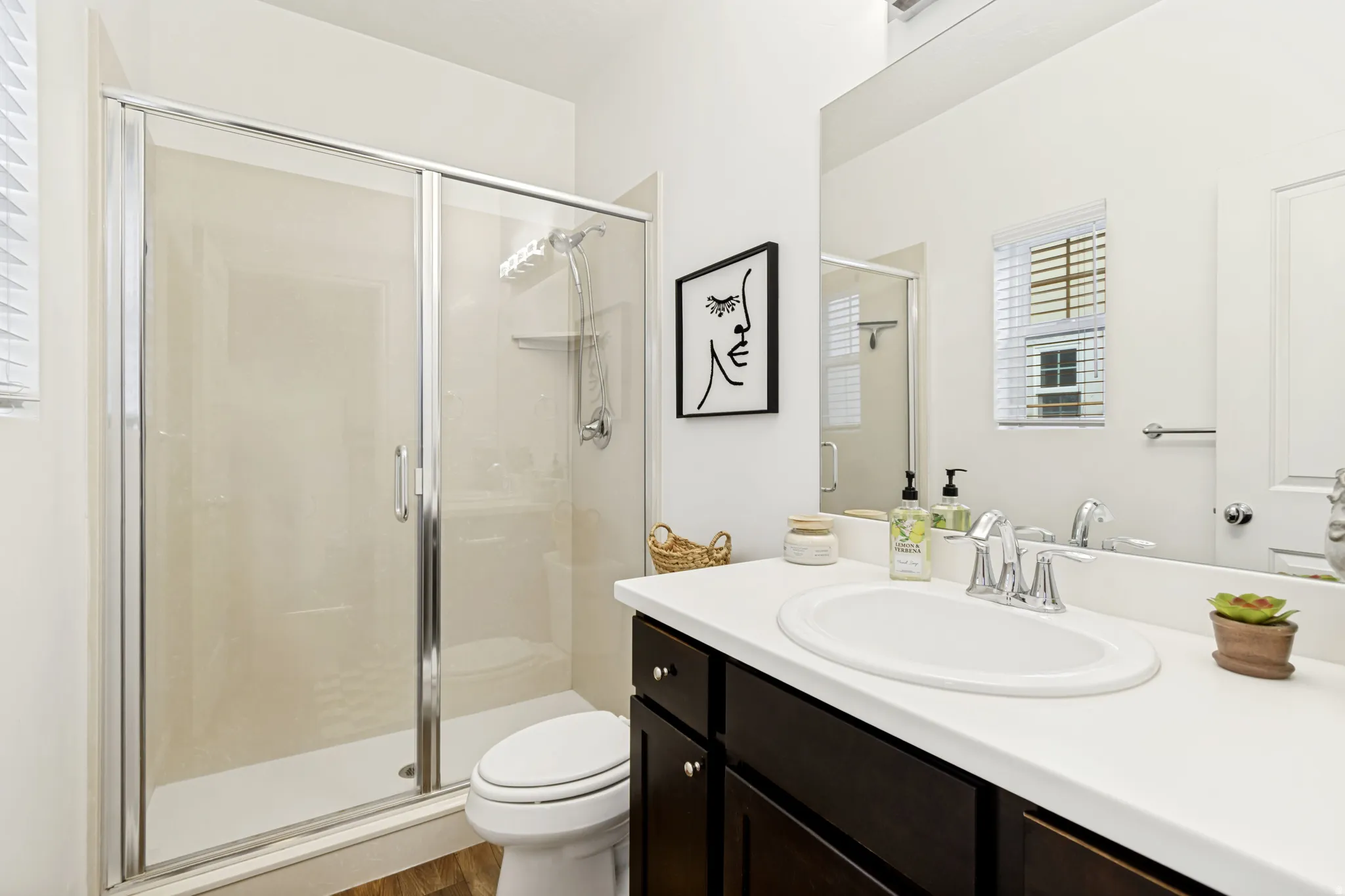 Full bathroom with vanity, a stall shower, and light wood finished floors