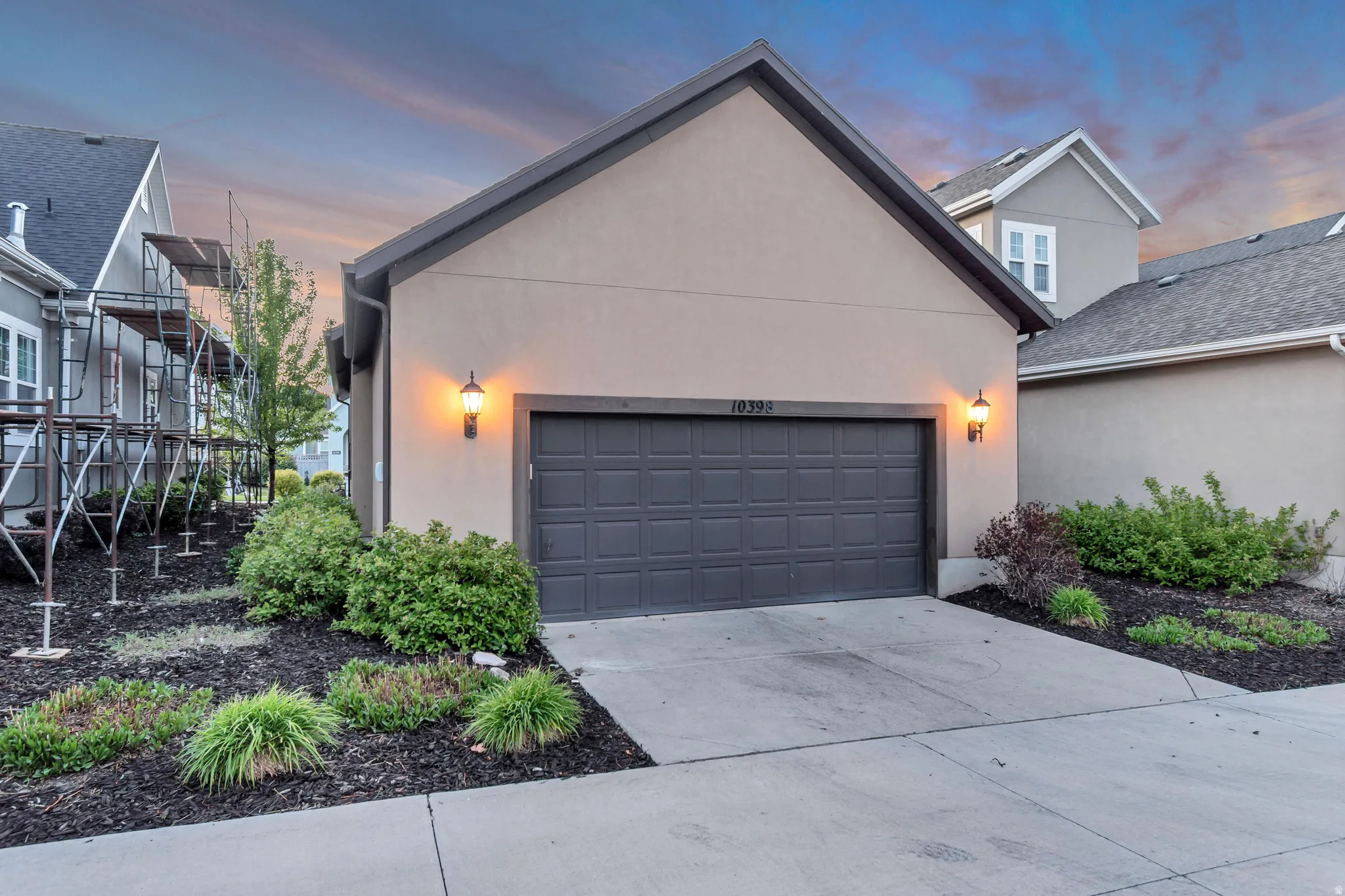View of front of house with stucco siding, an attached garage, and concrete driveway