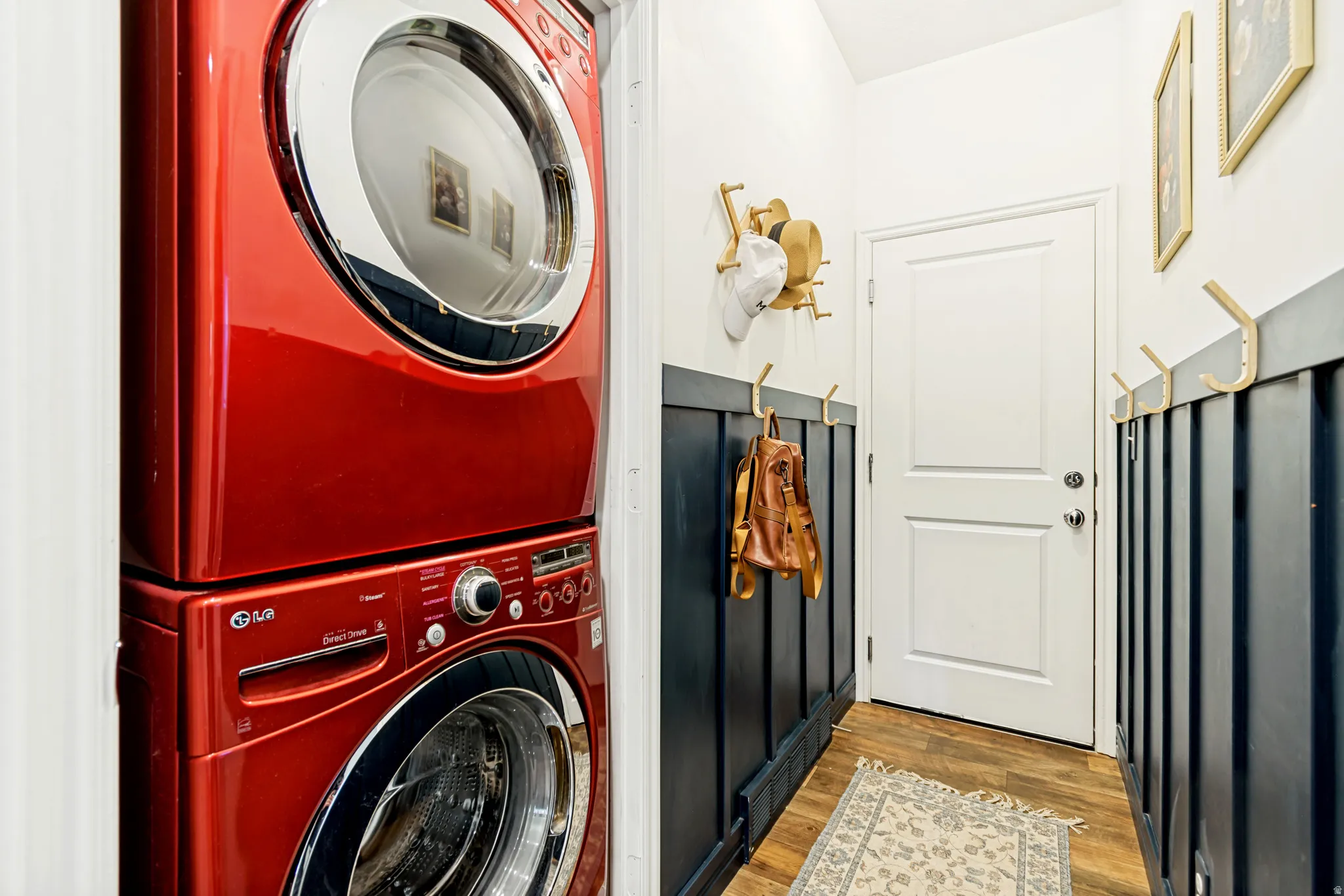 Laundry area featuring stacked washer / drying machine and light wood-style floors