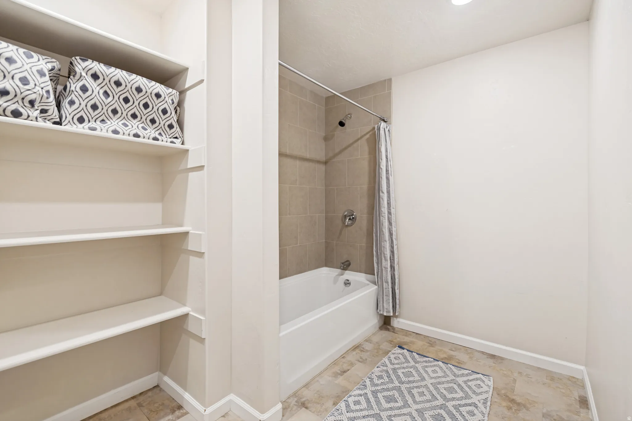 Bathroom featuring shower / bathtub combination with curtain and a closet