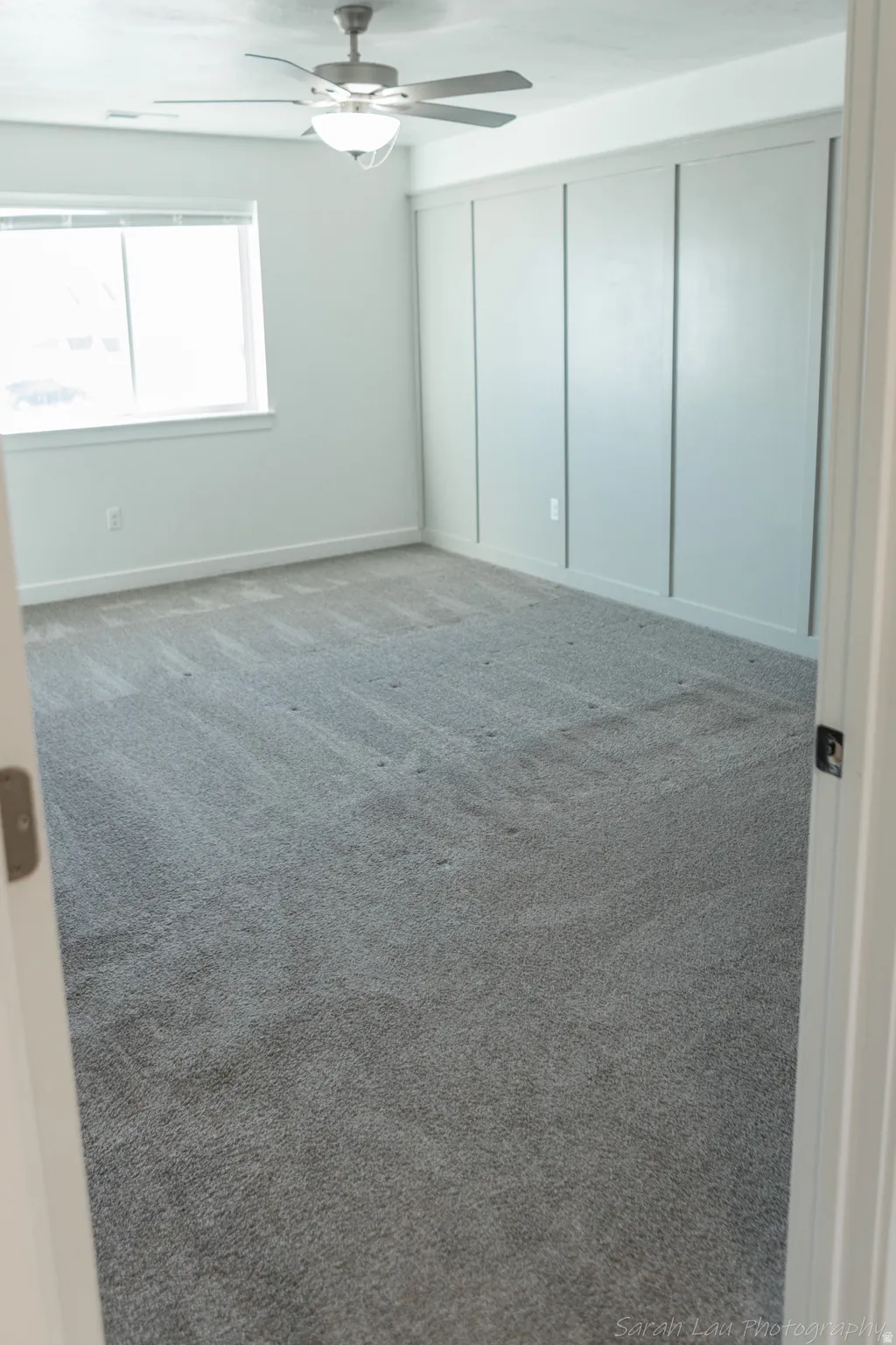 Unfurnished bedroom with light colored carpet and ceiling fan