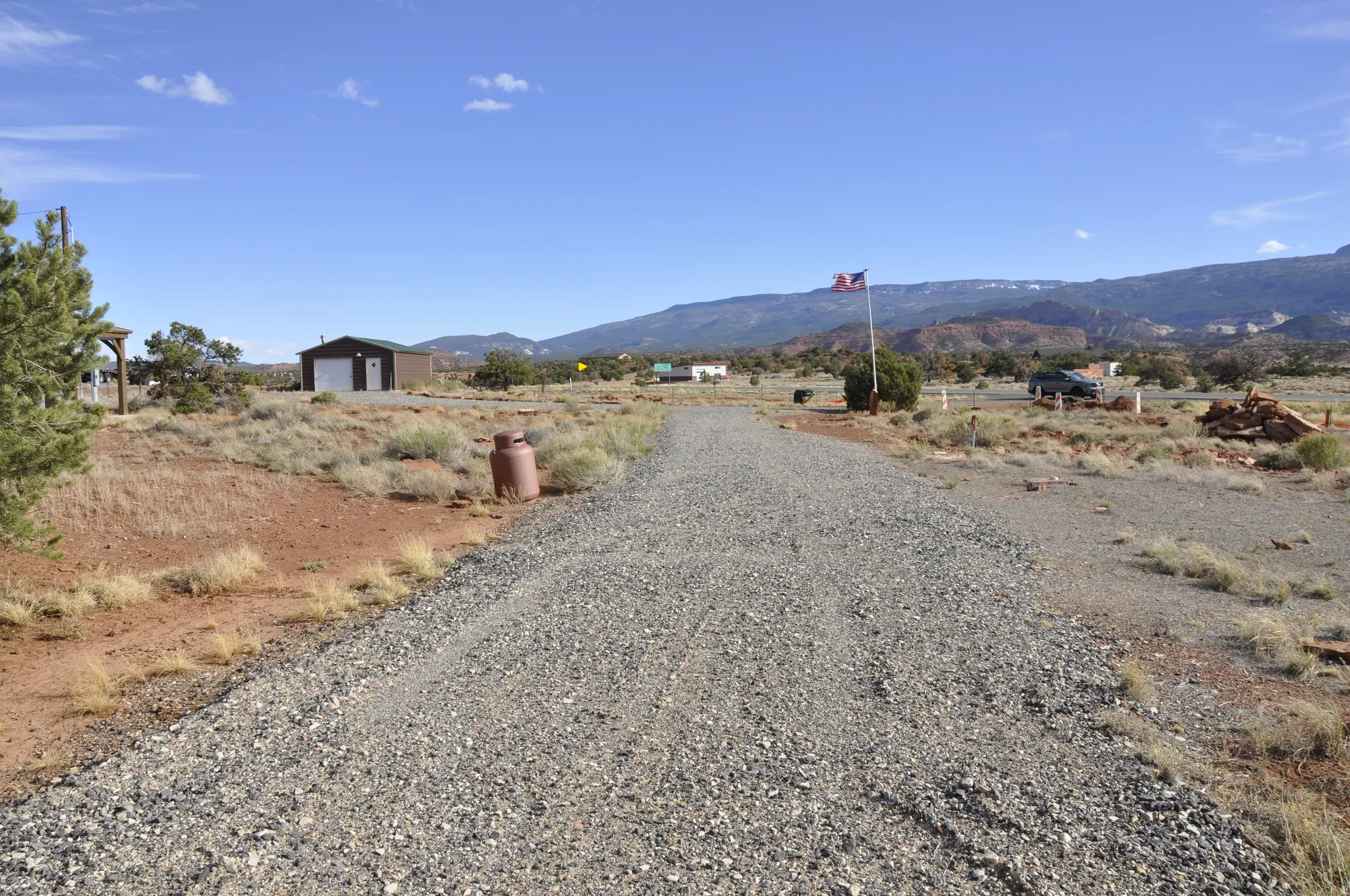 View of dirt / gravel road with a mountain view and a rural view