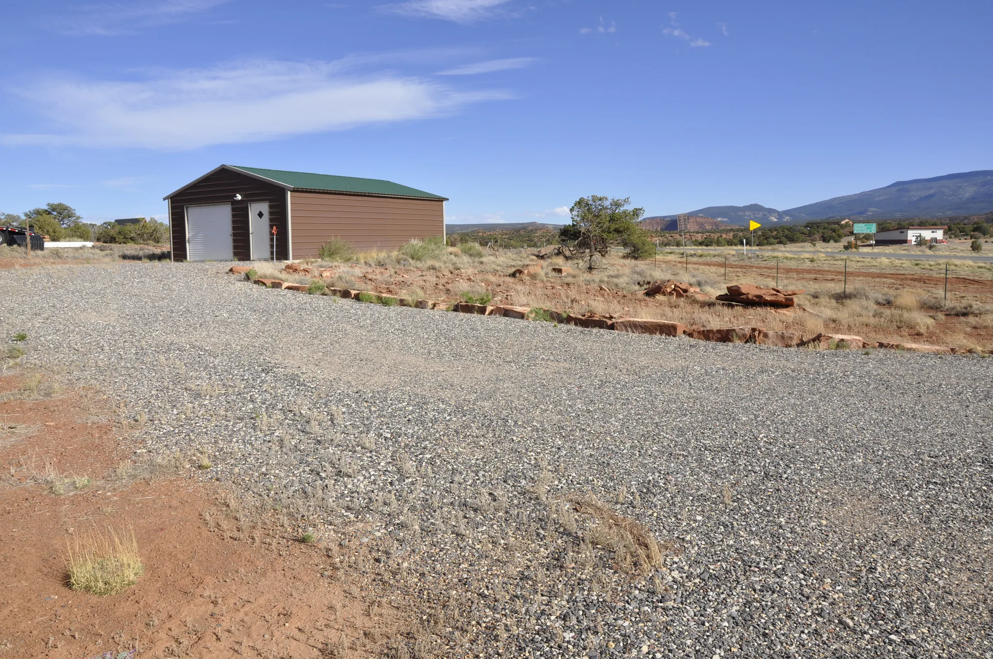 View of outbuilding with a rural view, a mountain view, and driveway