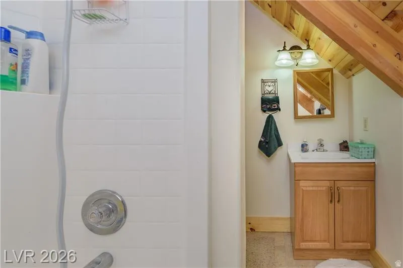 Bathroom featuring vanity, a vaulted wooden ceiling, and shower / bathtub combination