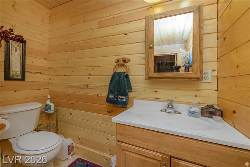 Half bath with wood walls and vanity