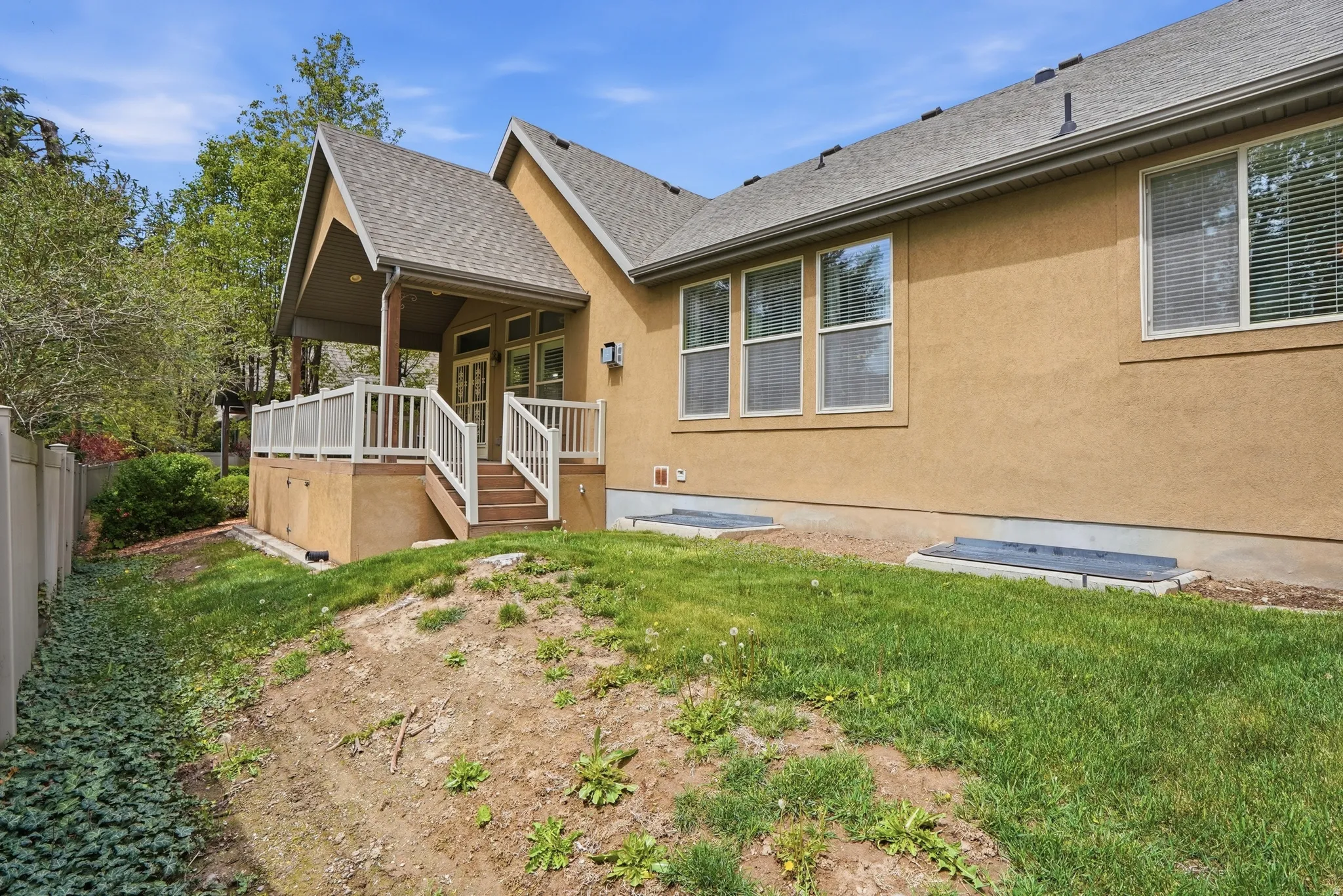 Rear view of property with roof with shingles, stucco siding, and a wooden deck