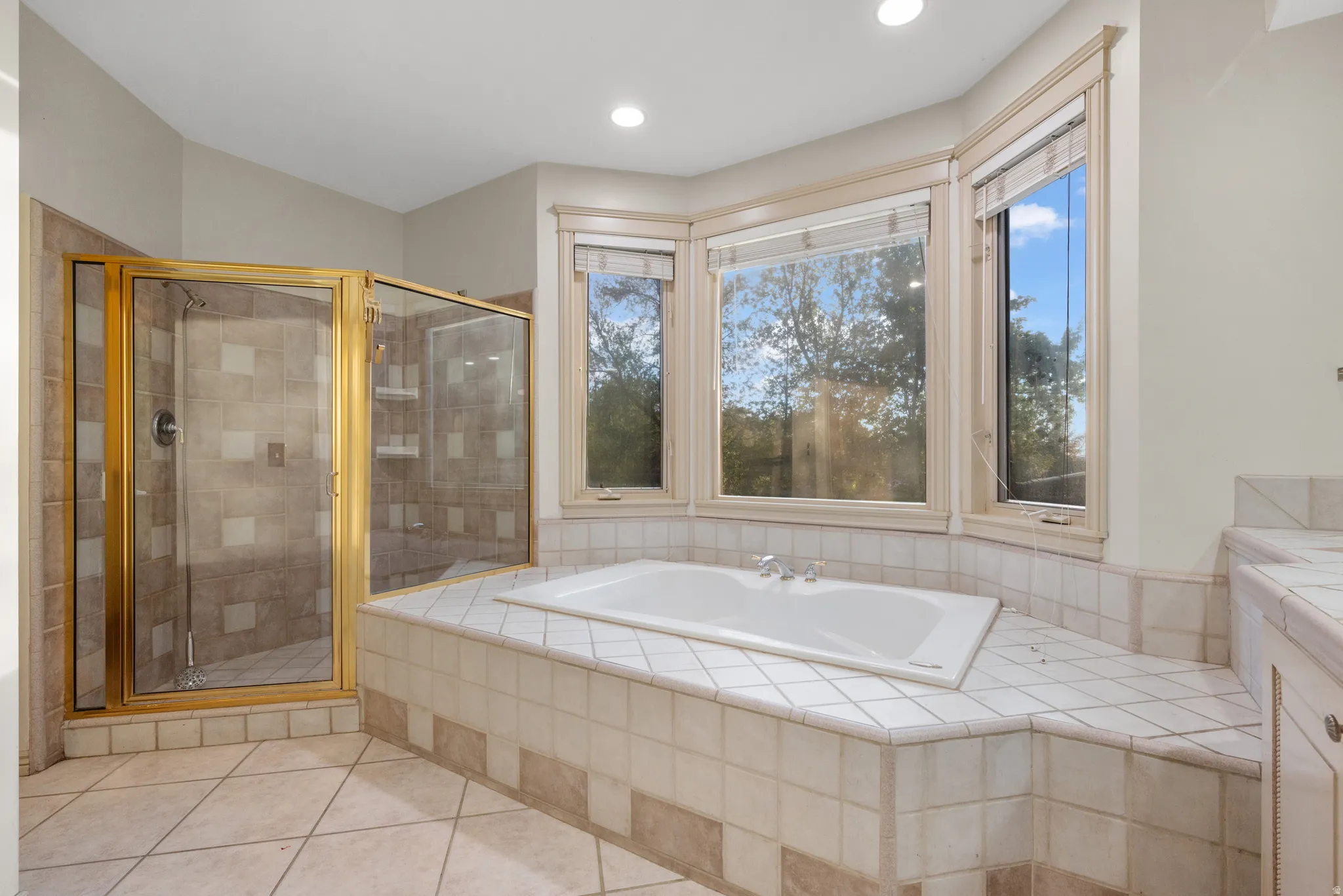 Primary Bathroom with a garden tub, a stall shower, and light tile patterned flooring