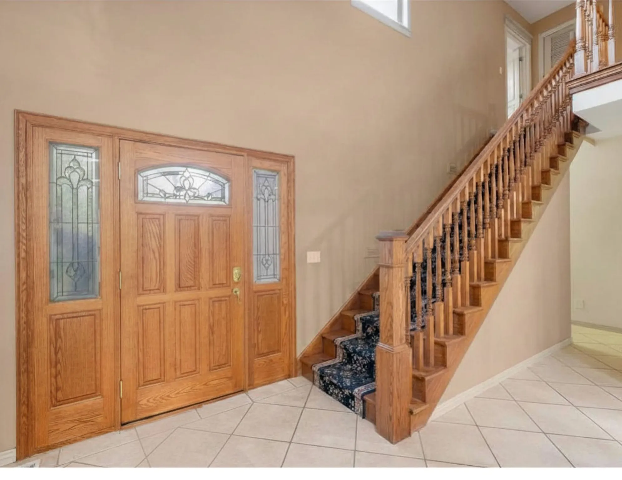 Foyer entrance with light tile patterned floors and a high ceiling