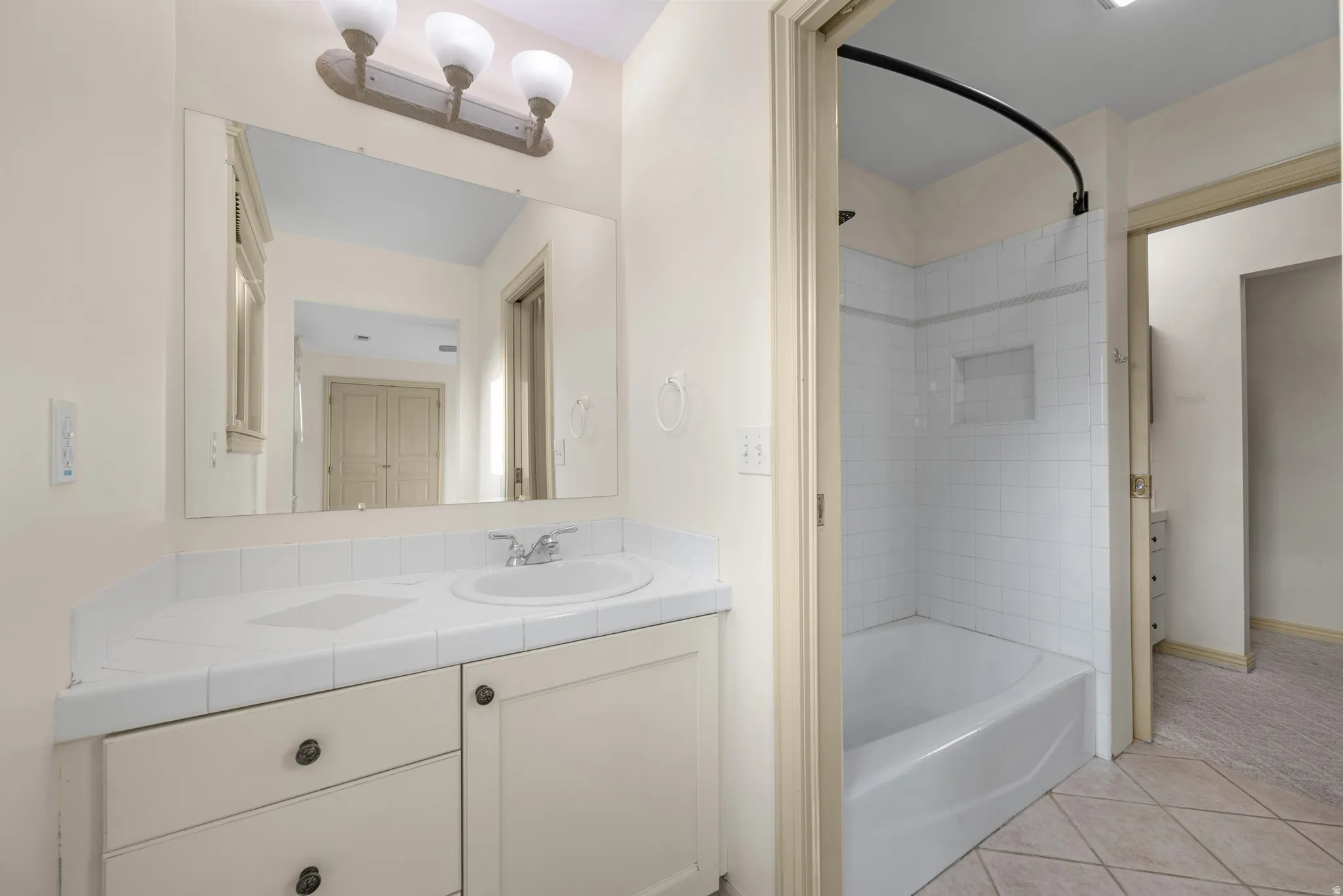 Bathroom featuring vanity, shower / bathtub combination, and light tile patterned floors
