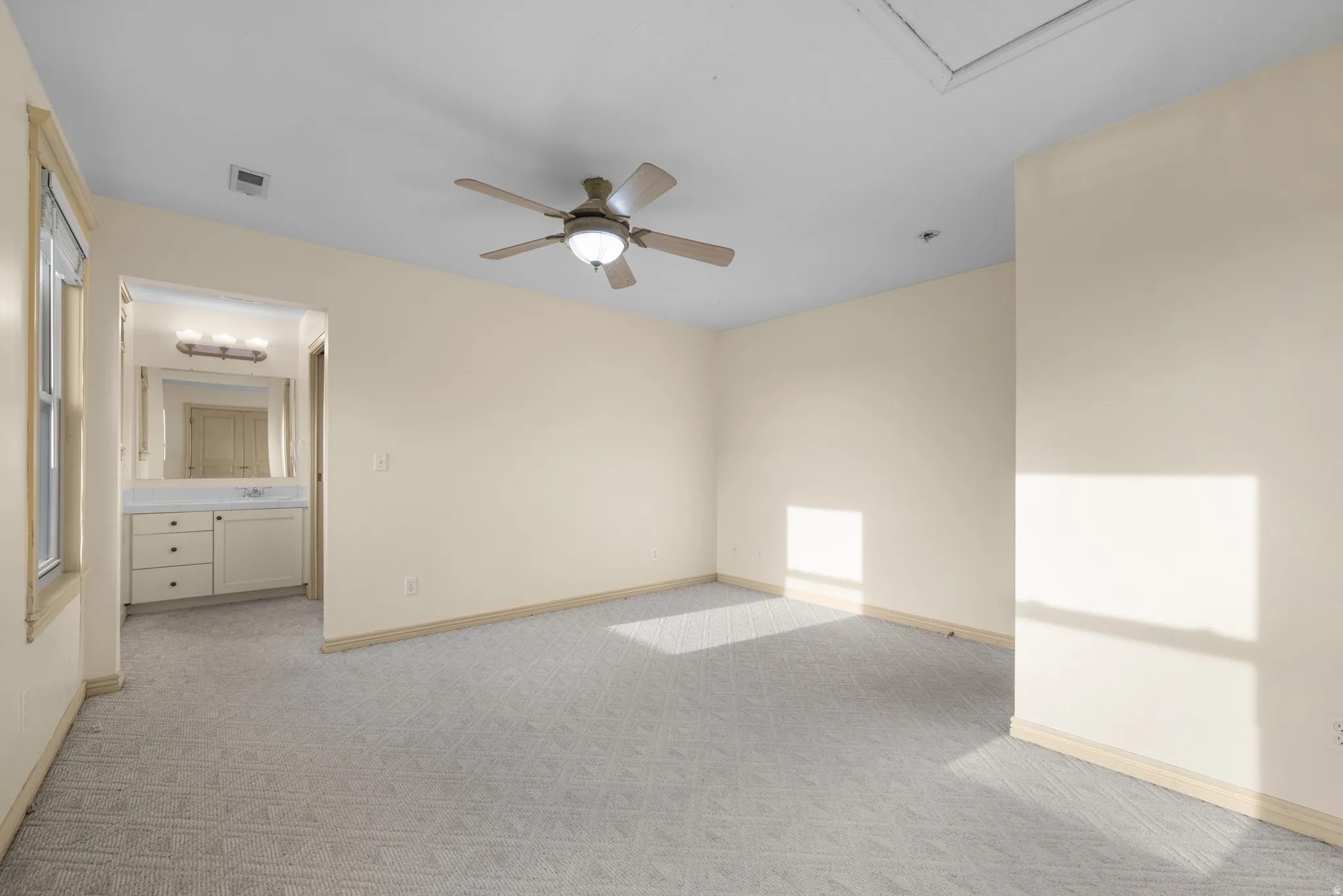 Unfurnished room with light carpet and ceiling fan with Jack & Jill Bathroom.