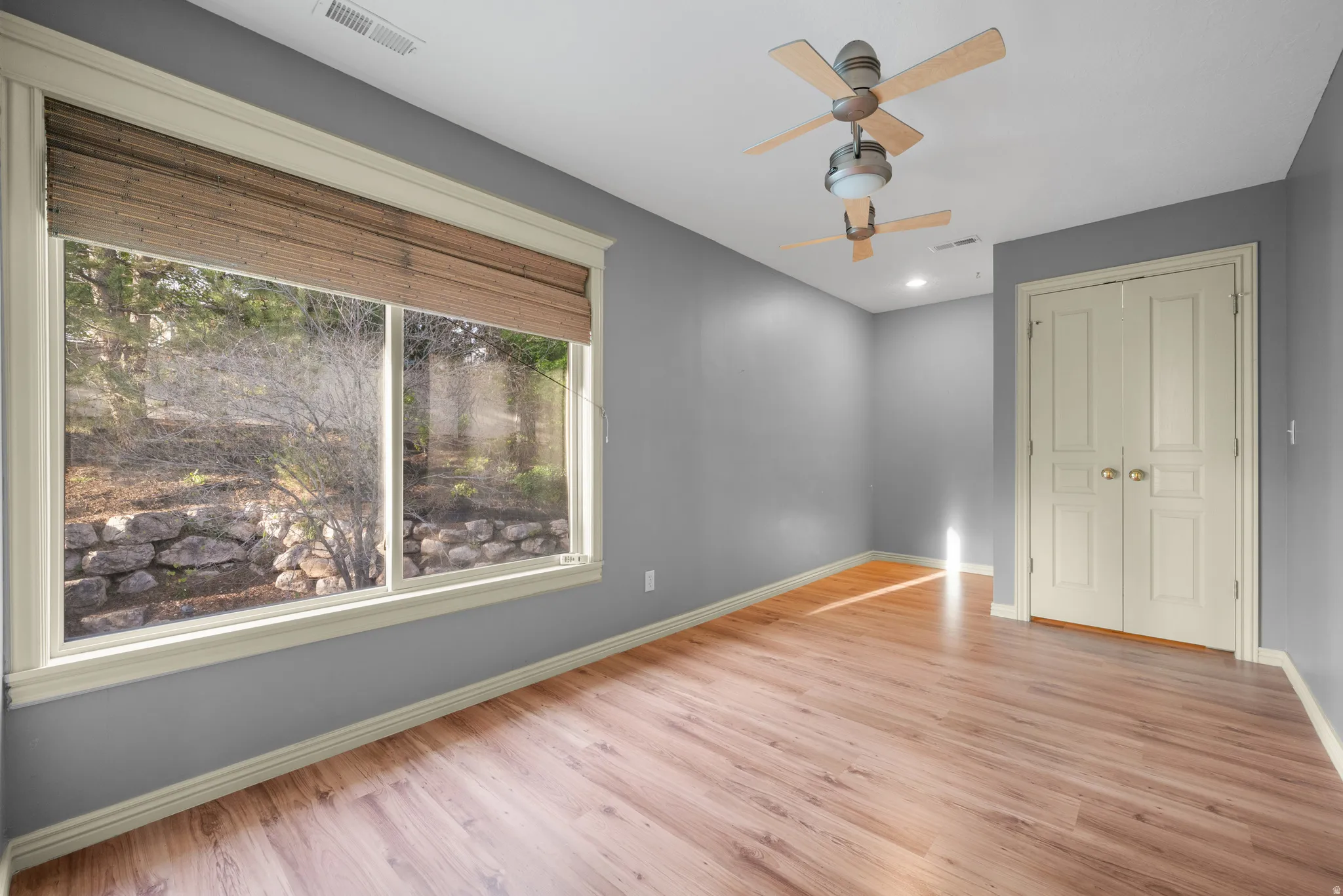 Unfurnished bedroom featuring light wood finished floors, a closet, and ceiling fan