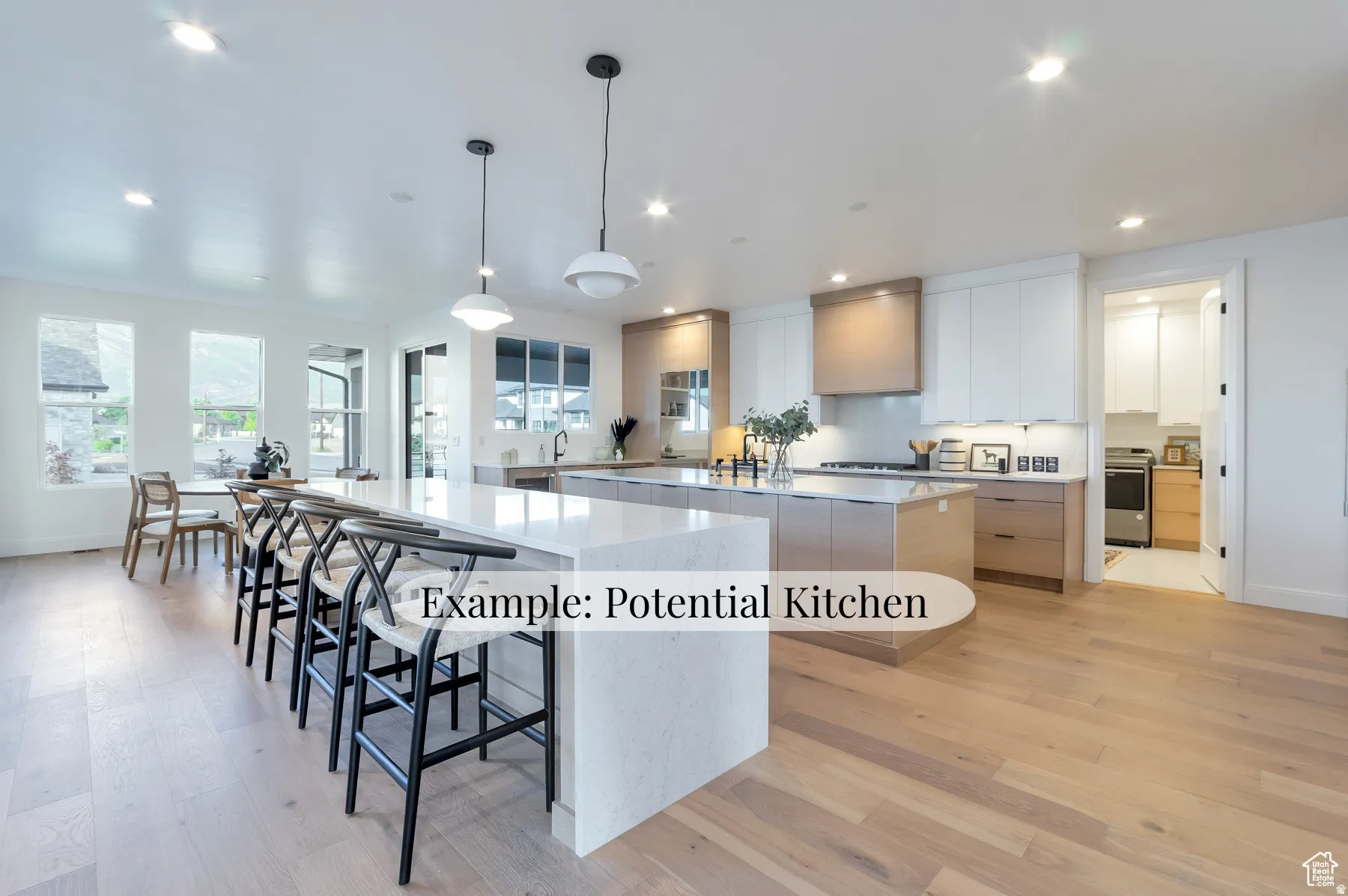 Kitchen with two tone cabinets, light wood-style flooring, light stone countertops, a kitchen breakfast bar, and modern cabinets
