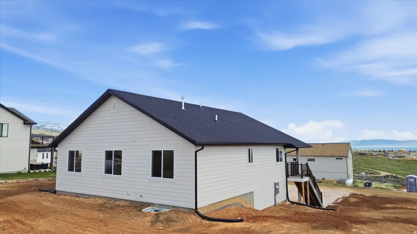 Rear view of property with a mountain view and roof with shingles