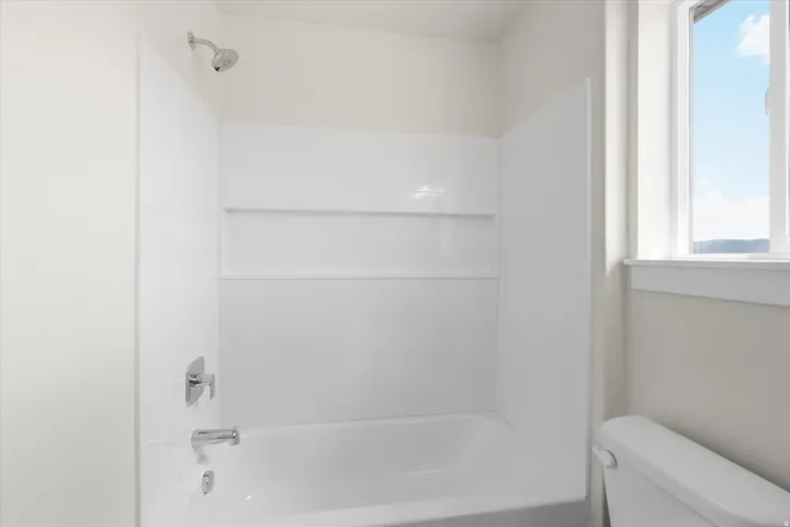 Bathroom with healthy amount of natural light and washtub / shower combination