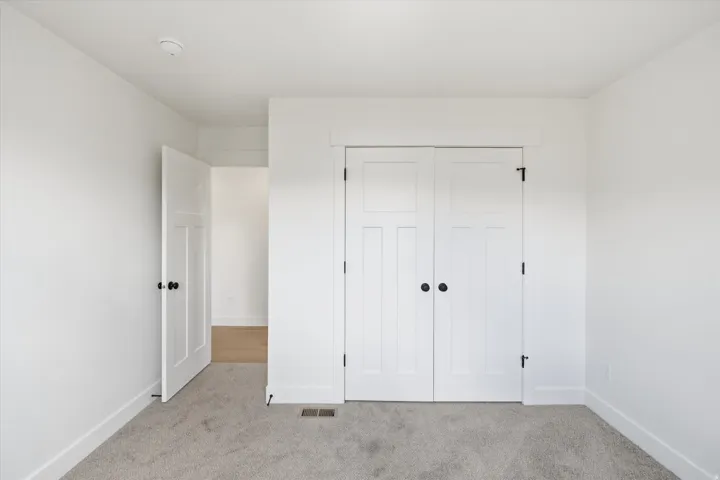 Unfurnished bedroom featuring light colored carpet and a closet