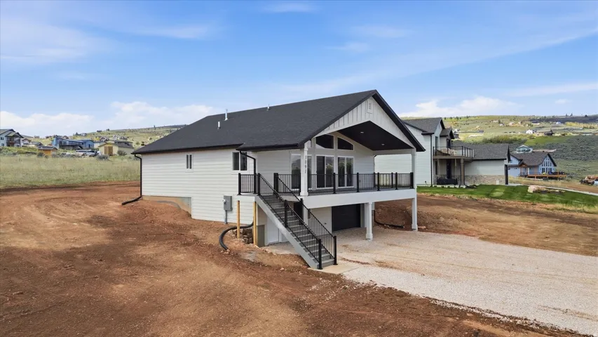 View of front facade with a garage, roof with shingles, driveway, a residential view, and board and batten siding