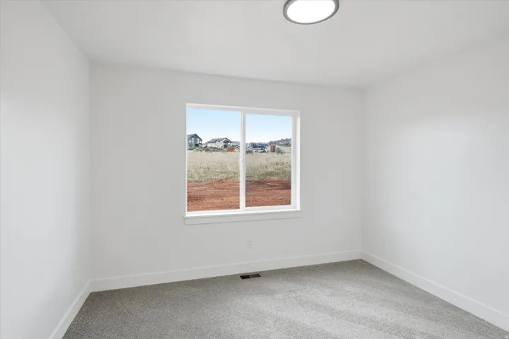 Unfurnished room with light carpet and baseboards
