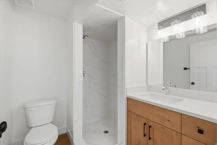 Full bath with vanity and a marble finish shower