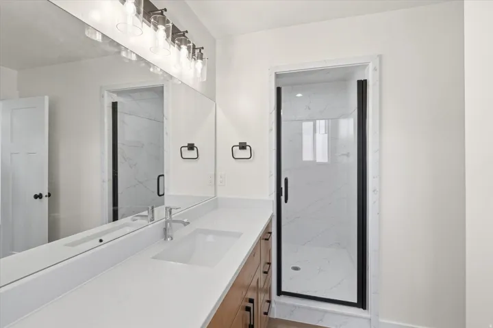 Full bathroom with a marble finish shower and vanity