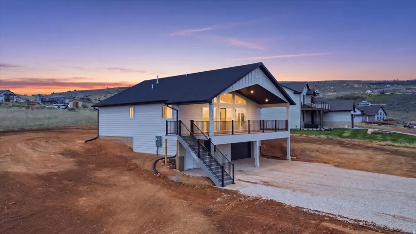 View of front of property featuring an attached garage, driveway, and a shingled roof