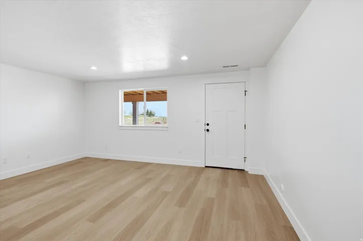 Empty room featuring light wood-style floors and recessed lighting