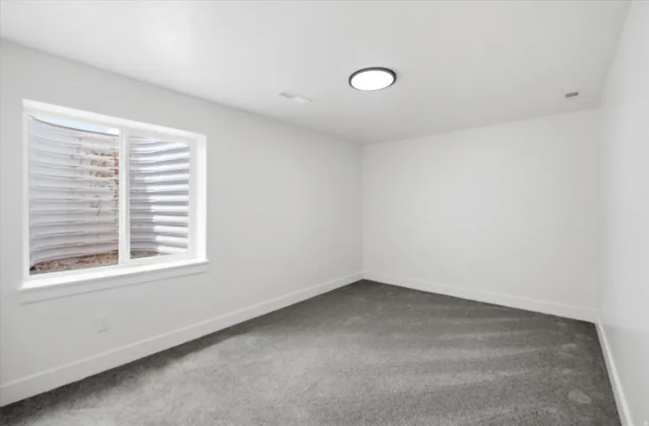 Empty room with carpet floors and baseboards