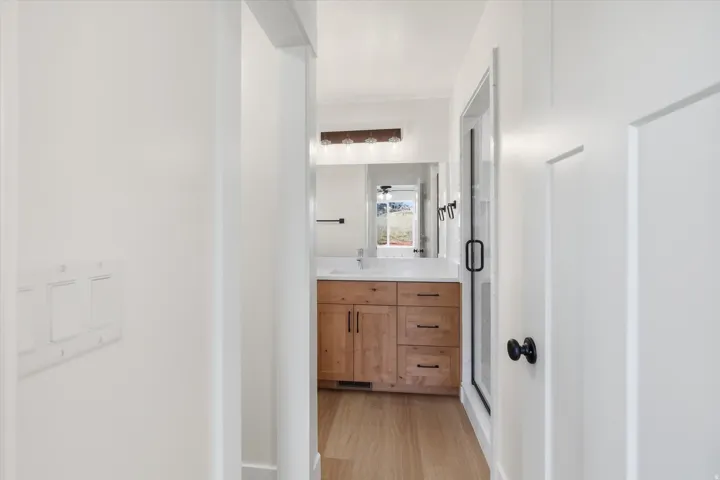 Bathroom featuring vanity, a shower stall, and light wood-style flooring