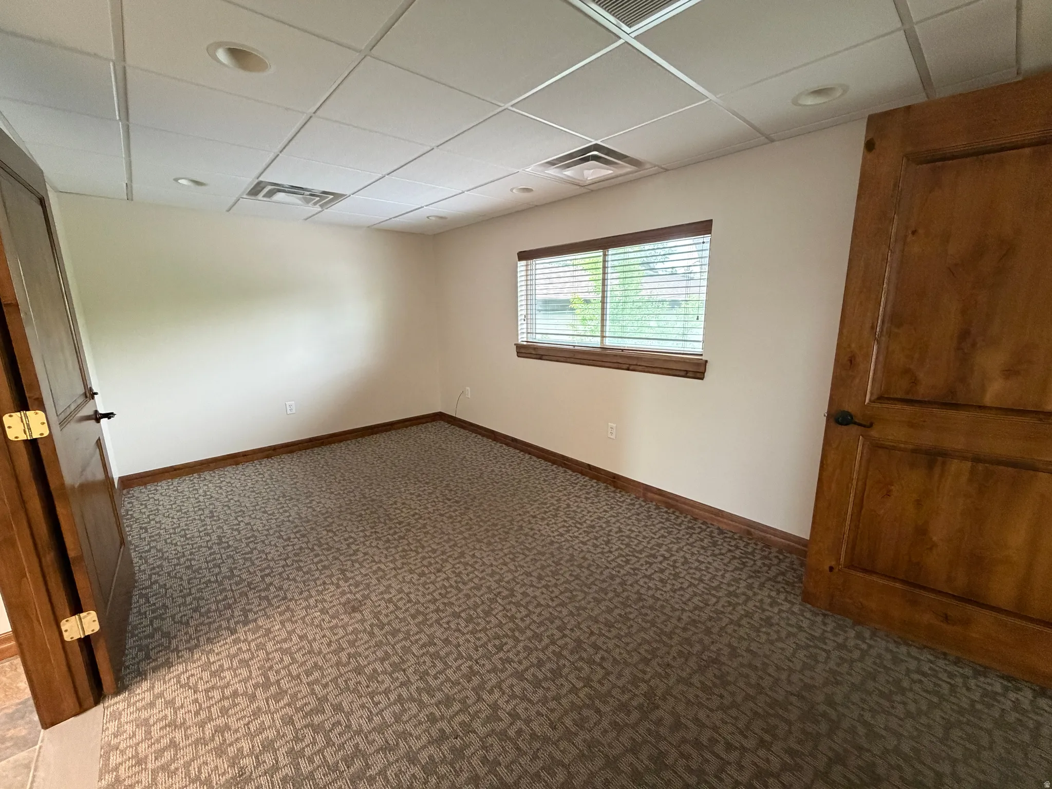 Spare room with a paneled ceiling and carpet