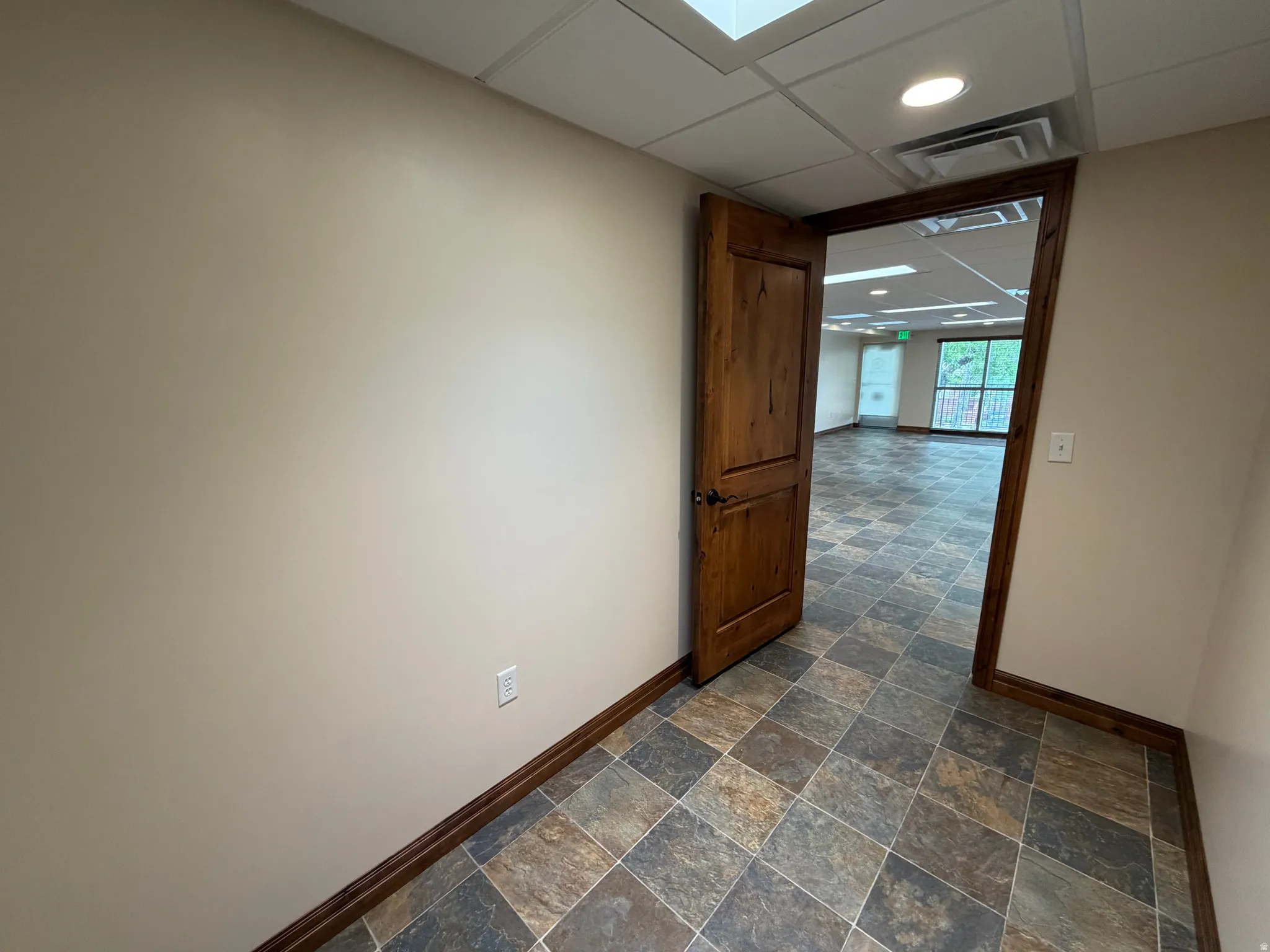 Unfurnished room with a drop ceiling, dark stone finish floors, and recessed lighting
