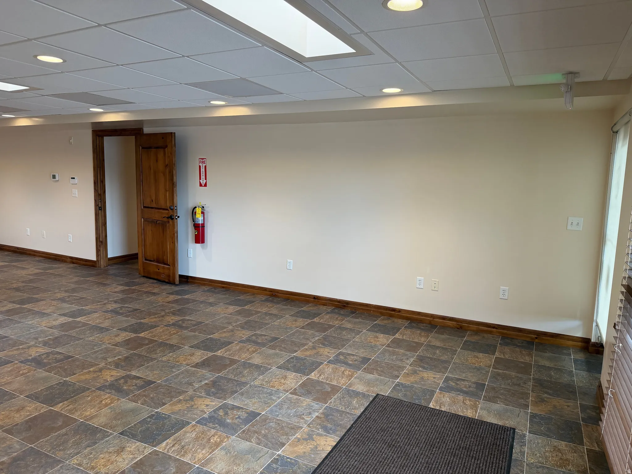 Empty room with a paneled ceiling and stone finish floors