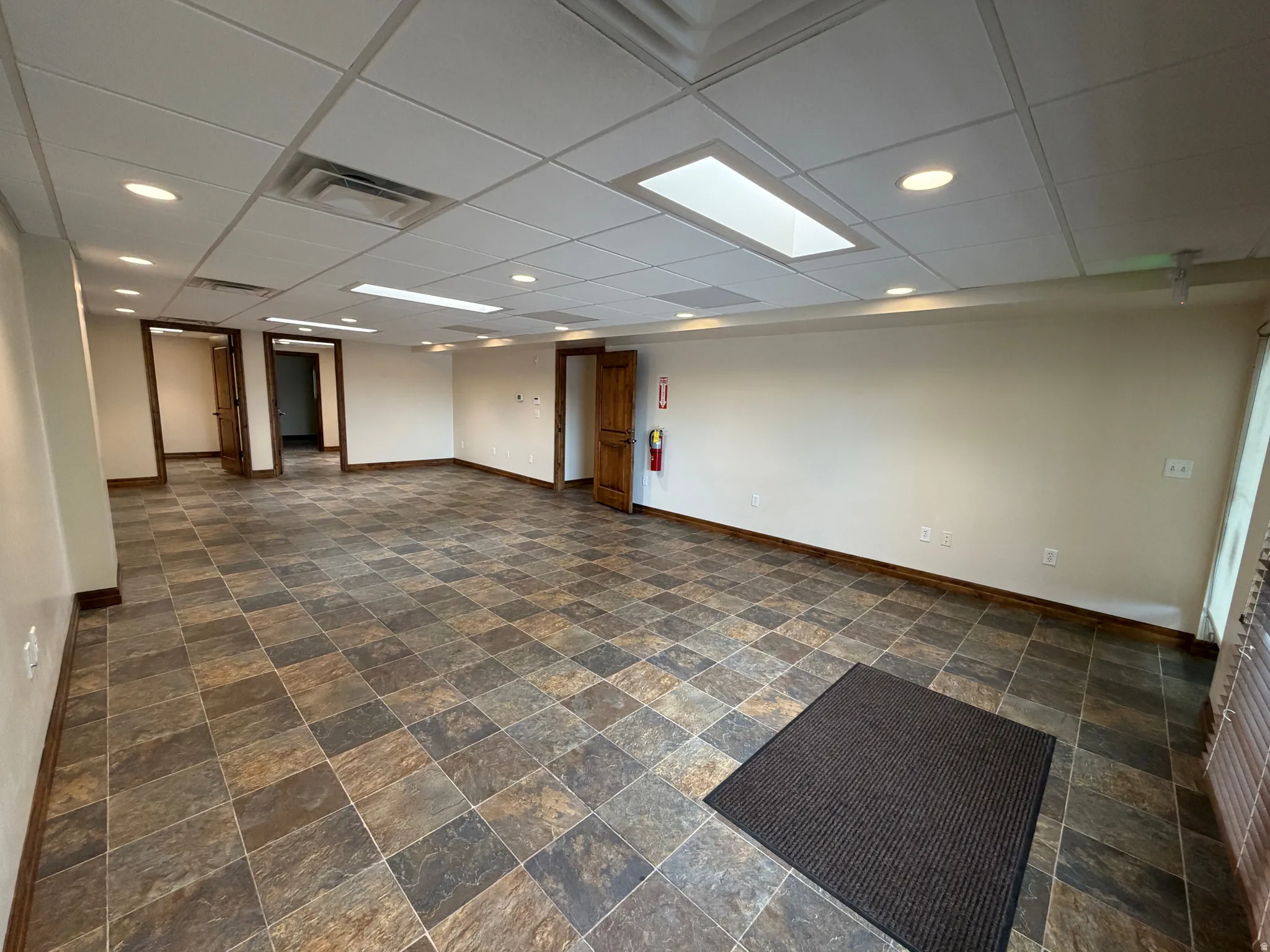 Finished below grade area with recessed lighting, dark stone finish floors, and a paneled ceiling