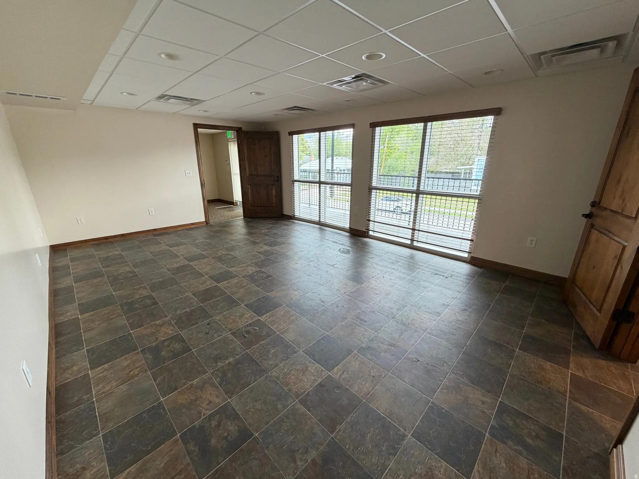 Spare room featuring a drop ceiling and dark stone finish floors