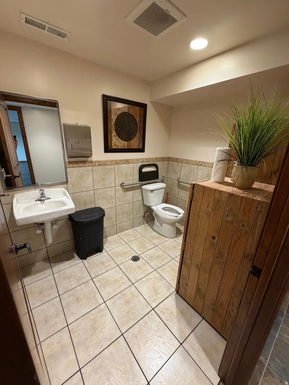 Bathroom with tile walls, wainscoting, and recessed lighting
