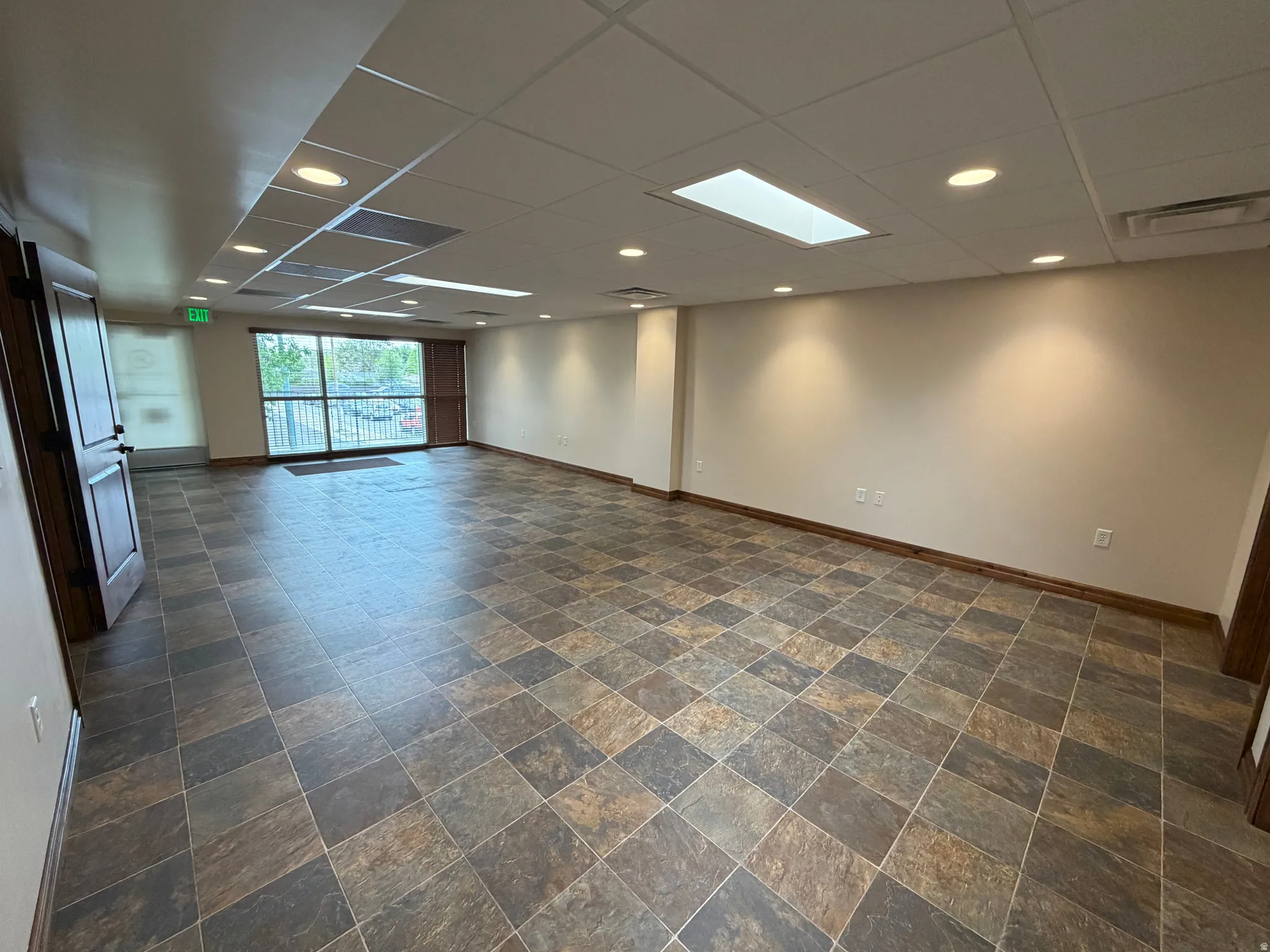 Spare room featuring a paneled ceiling, recessed lighting, and dark stone finish flooring