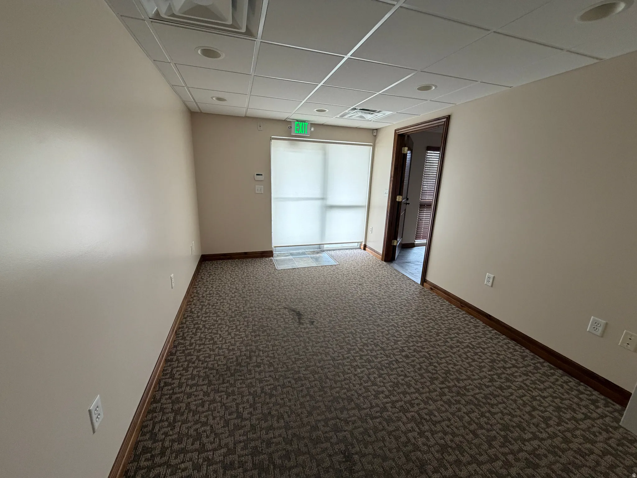 Spare room with a paneled ceiling and dark carpet
