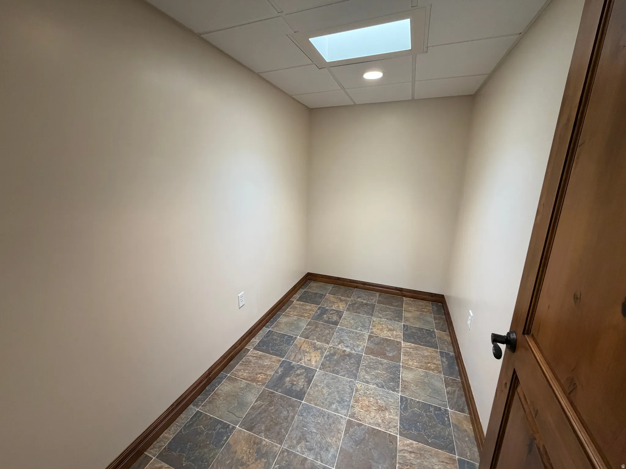 Spare room featuring a drop ceiling, stone finish floors, and recessed lighting