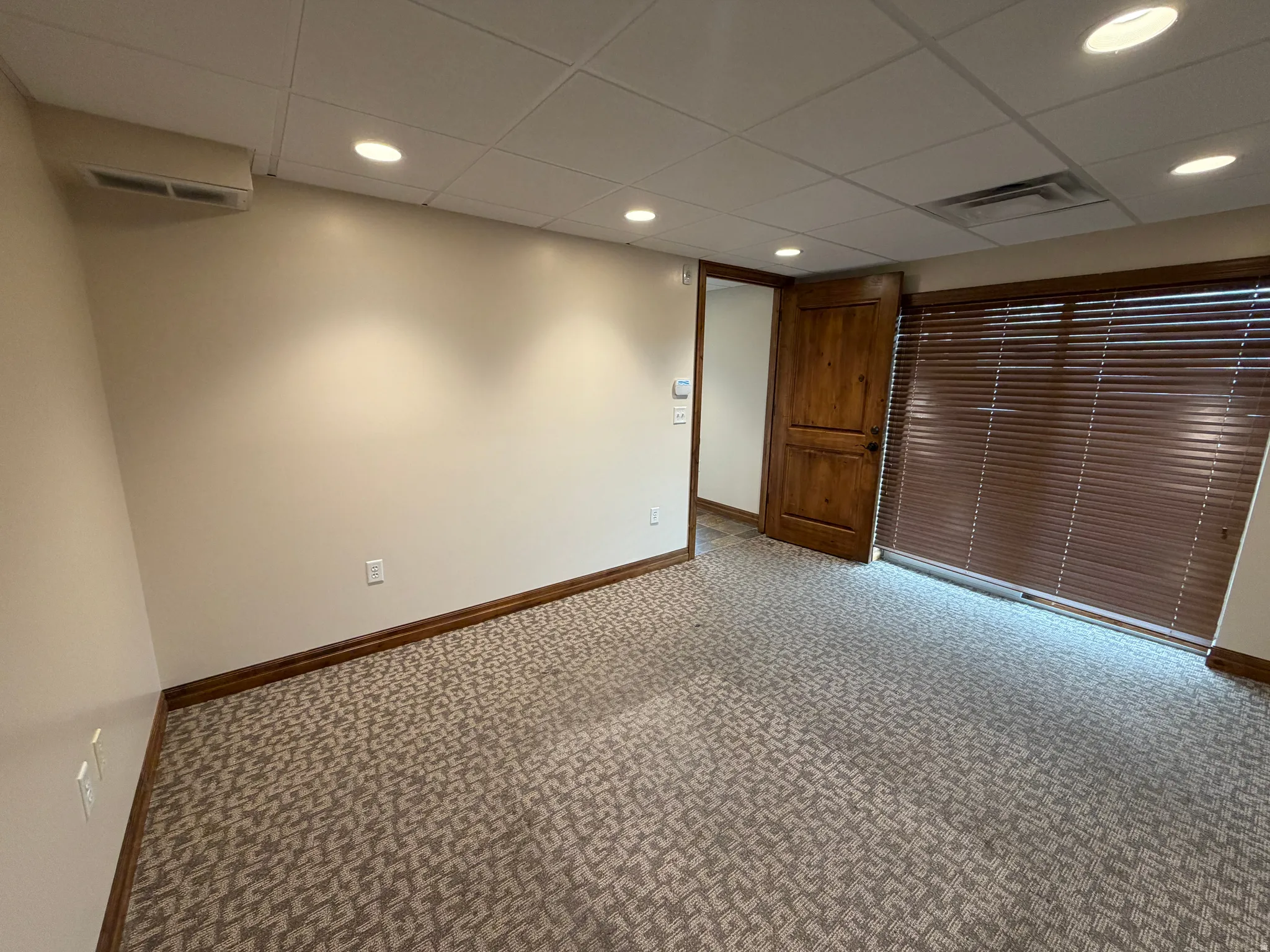 Carpeted spare room featuring a drop ceiling and recessed lighting