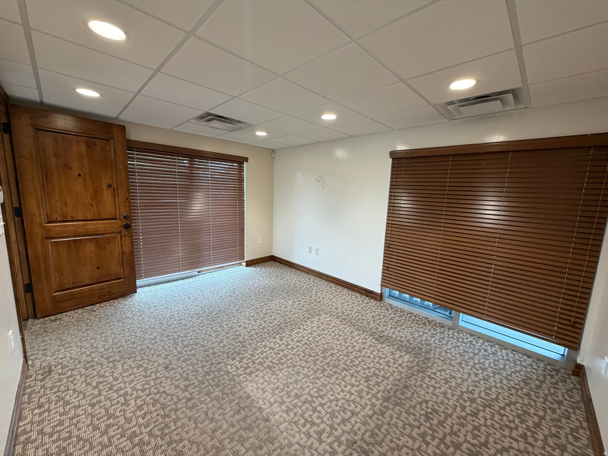 Unfurnished room with light carpet, recessed lighting, and a drop ceiling